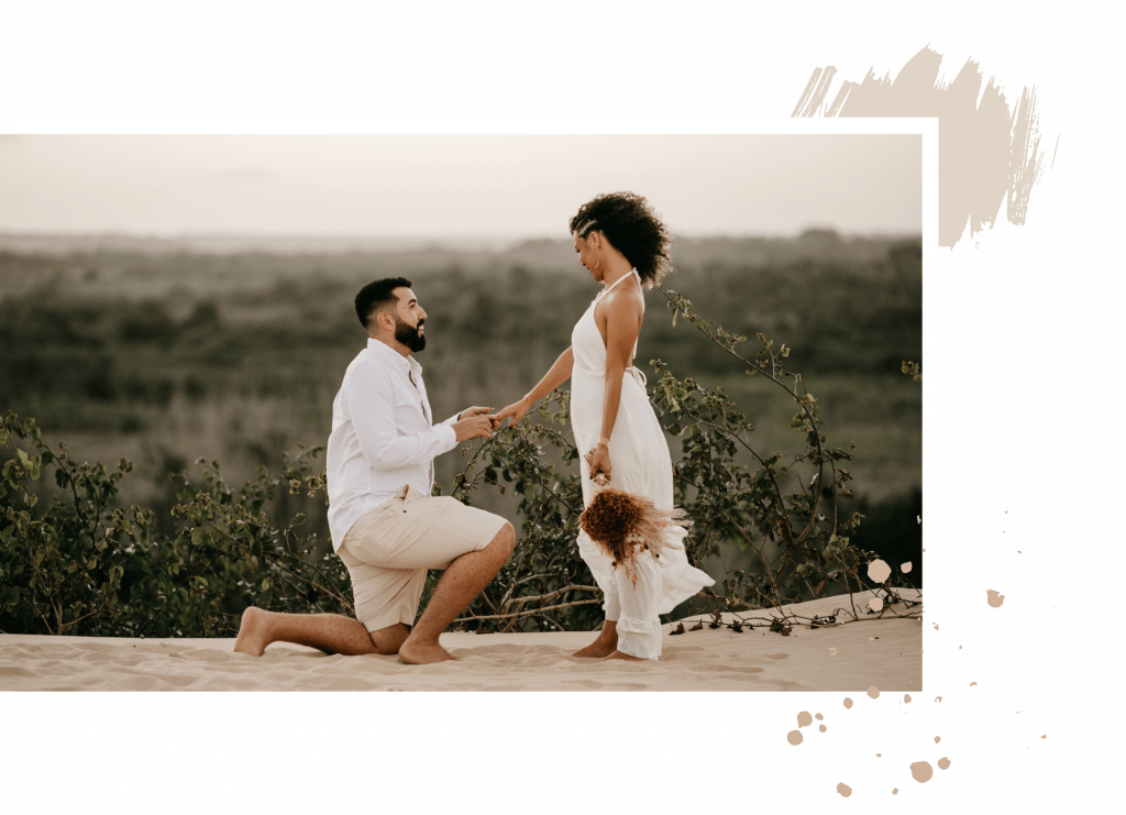 Mann kniet vor Frau und macht ihr einen Antrag